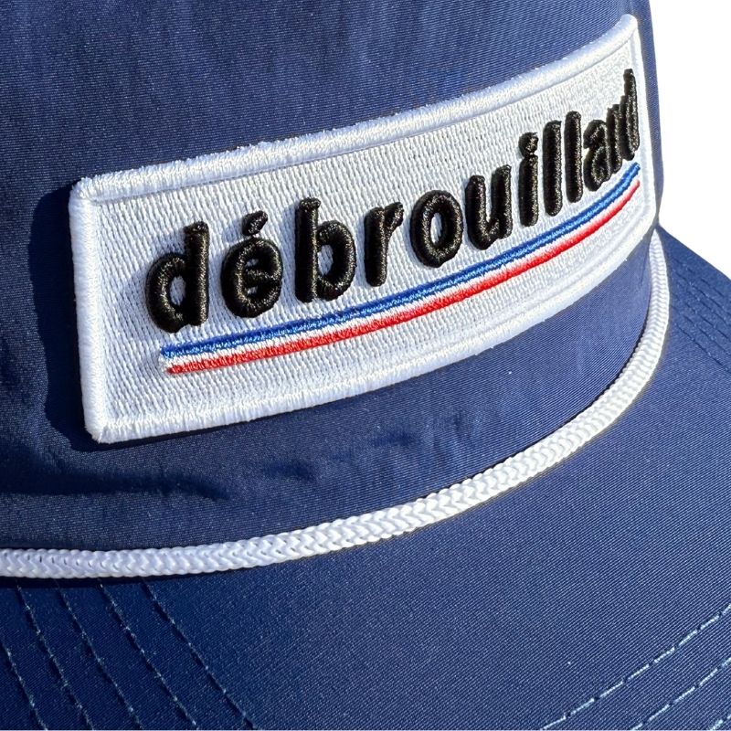 Débrouillard Logo Series Rope Hat in navy blue, shown from the front with detailed white embroidered logo.